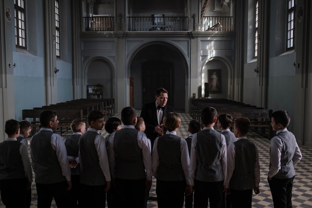 A church music minister leading a kid's choir.