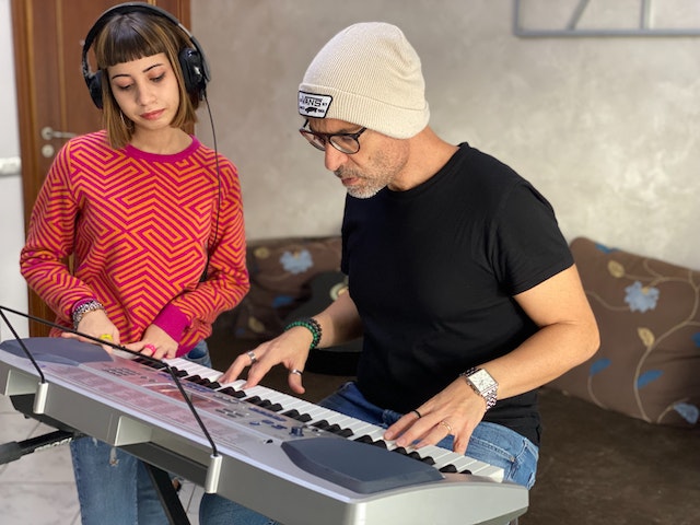A woman seeking her mentor's guidance on playing the keyboard.