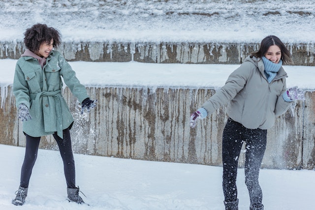 Two girls having a snowball fight.