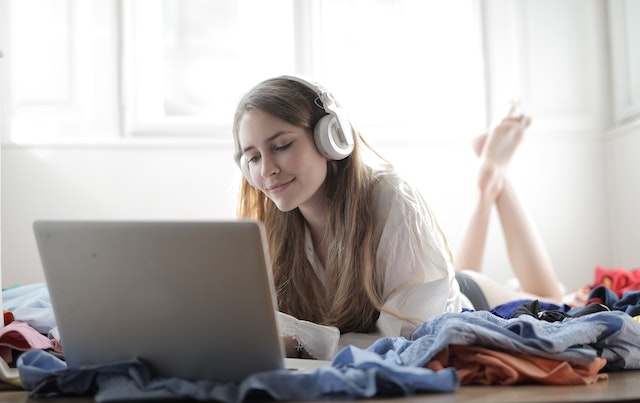 A woman listening to a podcast on her laptop.
