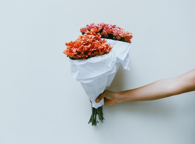 A person handing out bouquets of flowers.
