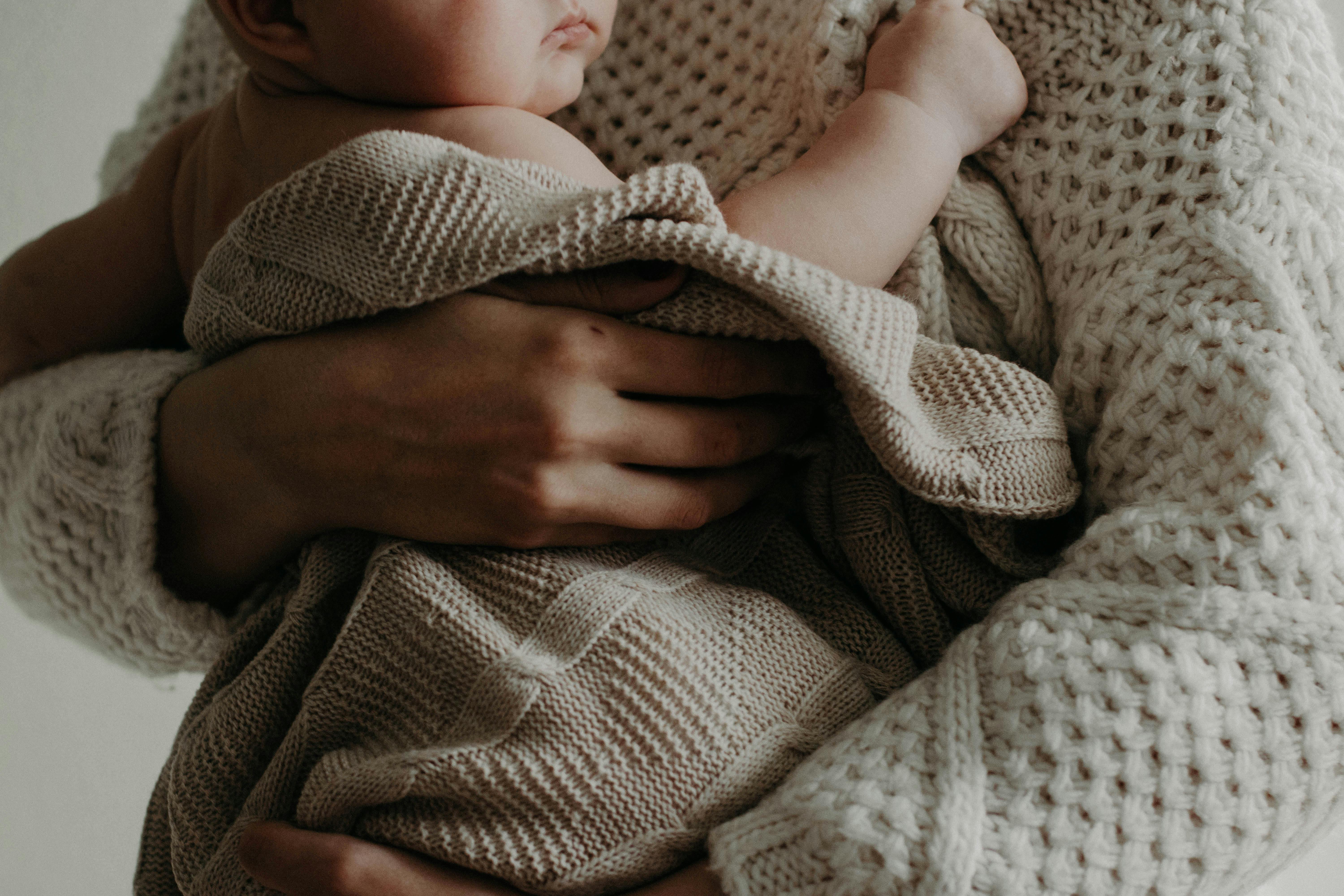 mom holding baby wrapped in a blanket