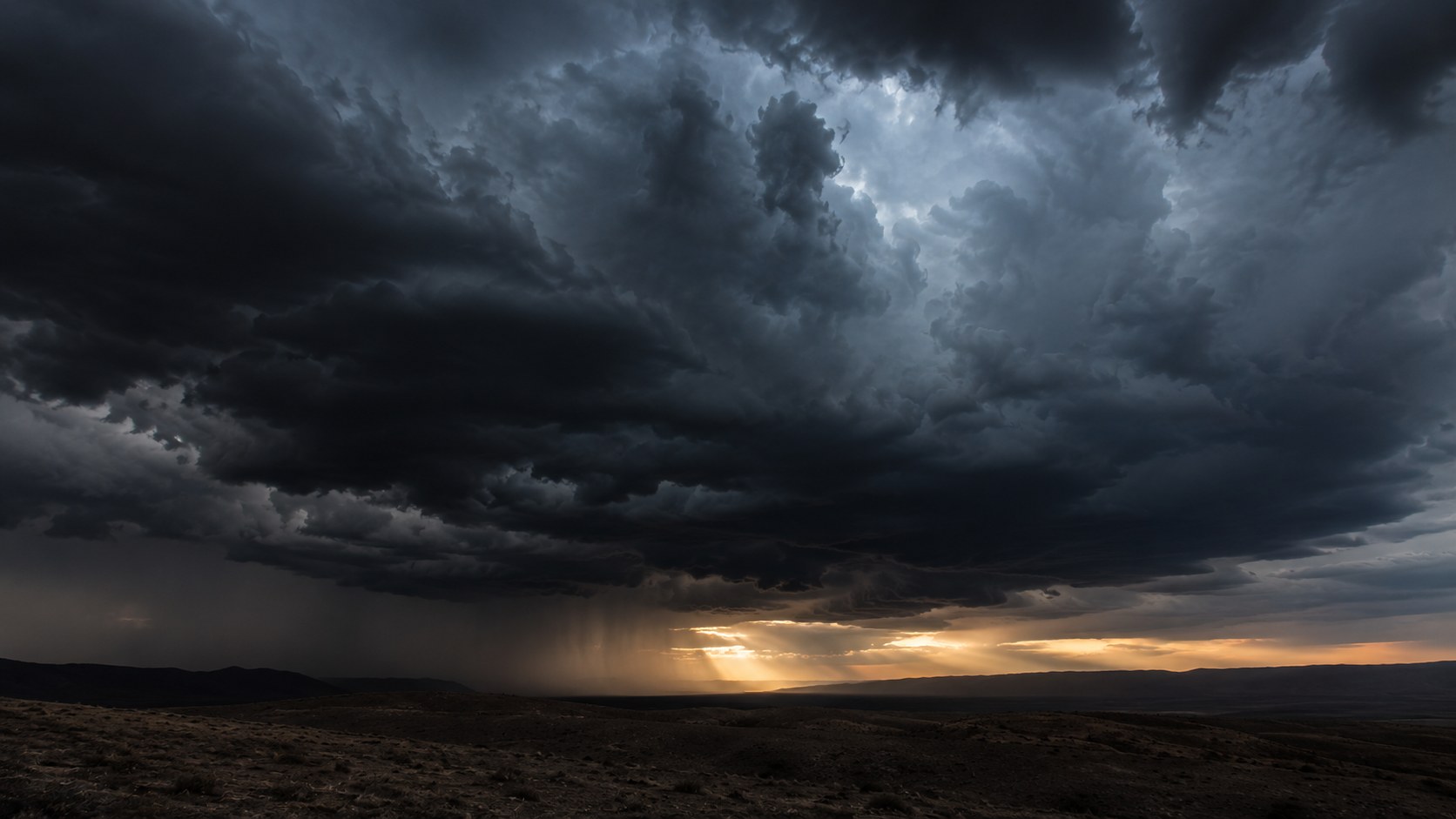 Dark storm clouds over a horizon, a picture of the principalities and powers Paul describes