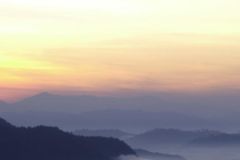 안개를 뚫고 떠오르는 산 위의 해
