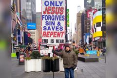 Brasileiro evangeliza com placa na Times Square: "Apenas Jesus salva, arrependam-se!"
