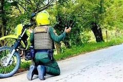 Policial se ajoelha para orar na Colômbia, em meio à onda de mortes no país