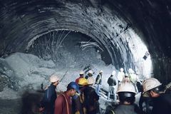 Rescuers dig for workers trapped in collapsed tunnel in India