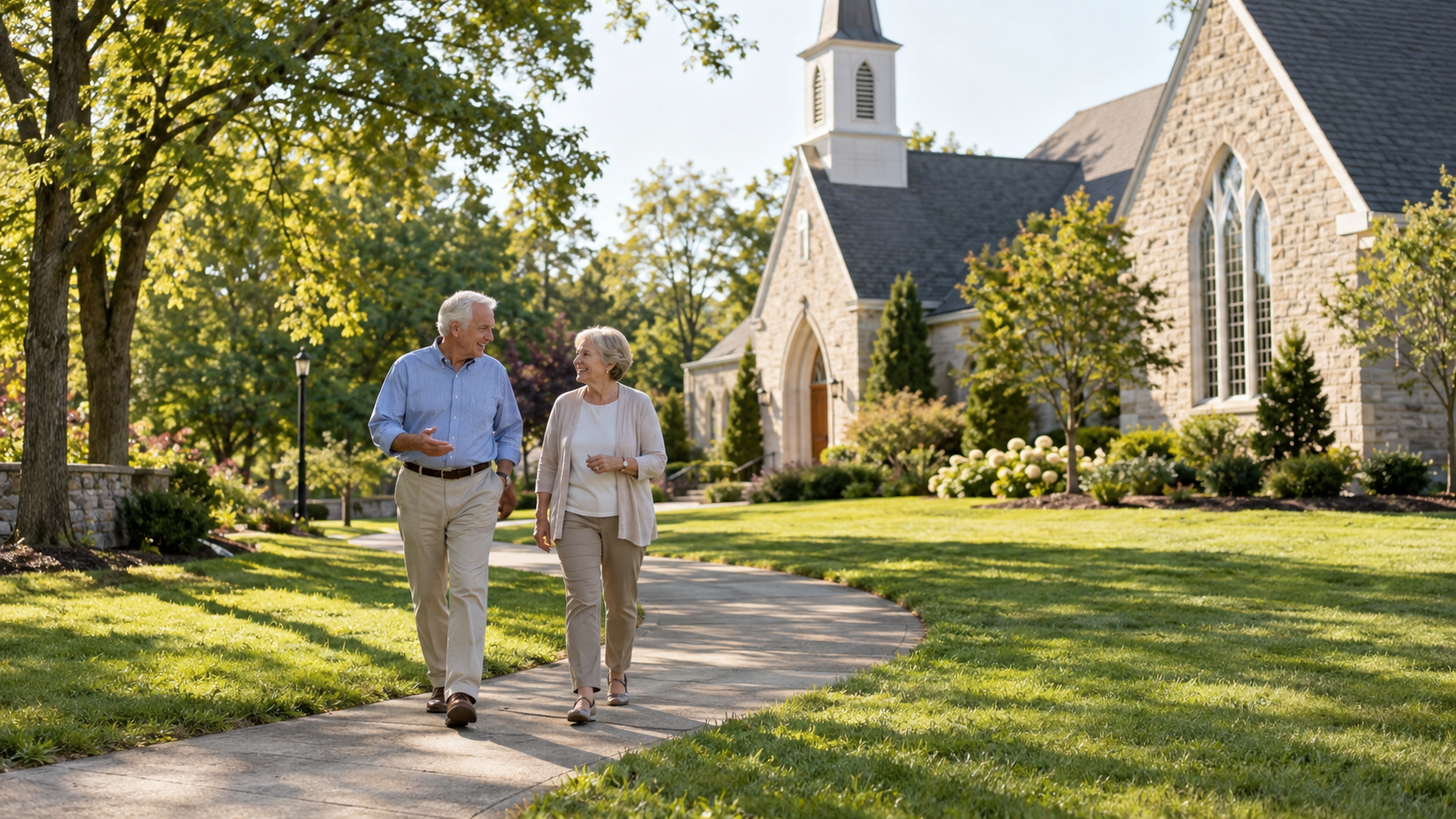 Two older adults walking side by side and talking on a paved path beside a suburban church, surrounded by green lawns and trees on a sunny afternoon.