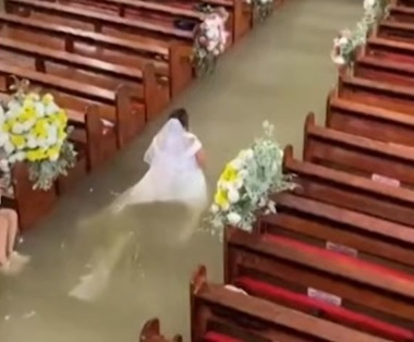 Couple marries in flooded church after monsoon in Philippines; bride walks the aisle in waist-deep water